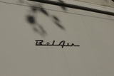 Chrome 'Bel Air' emblem on a light-colored RV rental, showcasing its classic lettering and surface reflections.