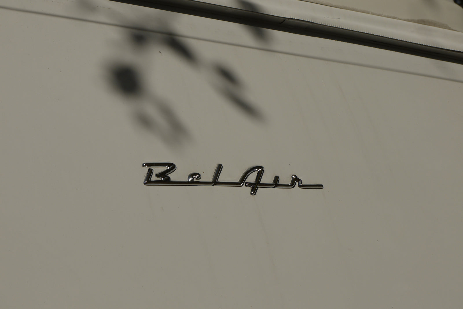 Chrome 'Bel Air' emblem on a light-colored RV rental, showcasing its classic lettering and surface reflections.