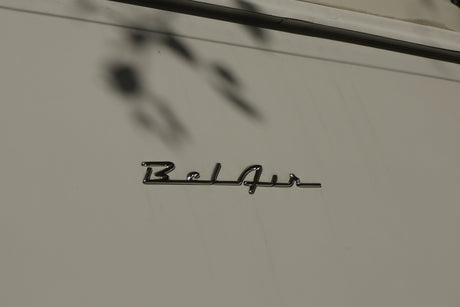 Chrome 'Bel Air' emblem on a light-colored RV rental, showcasing its classic lettering and surface reflections.