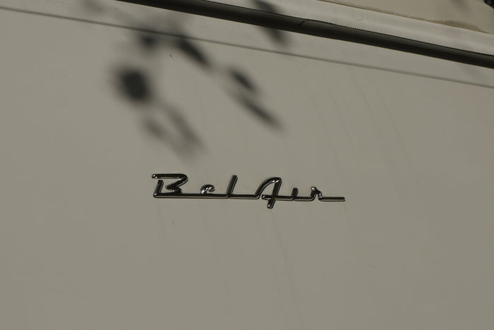 Chrome 'Bel Air' emblem on a light-colored RV rental, showcasing its classic lettering and surface reflections.
