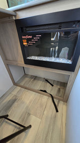 RV rental interior: cozy Innoflame electric fireplace with crystal media, built into wood cabinetry, offering warmth and storage.