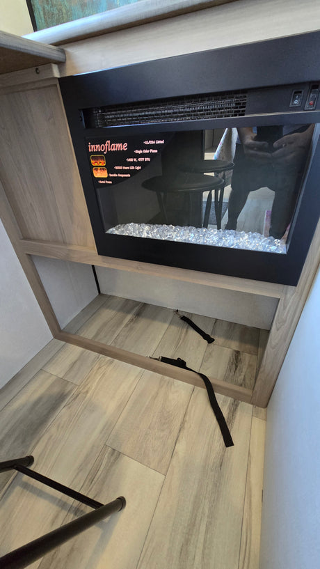 RV rental interior: cozy Innoflame electric fireplace with crystal media, built into wood cabinetry, offering warmth and storage.