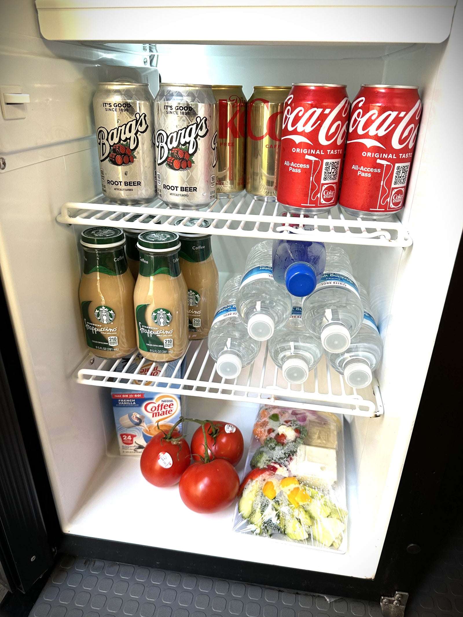 This rv rental mini-fridge is stocked with Barq's, Coke, Starbucks, water, Coffee-mate, fresh tomatoes, and pre-cut veggies.