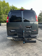 Rear of a dark GMC van with a bike rack & "WILD" decal, perfect for an rv rental outdoor escape.