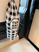 This checkered "BAG BAG" hangs inside an RV rental, offering clever storage for your camper van adventures.