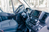 Explore the modern interior of an RV rental: driver's seat, steering wheel, and tech-equipped dashboard await your adventure.