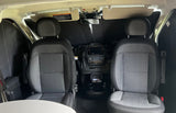 Front cabin of an RV rental: two upholstered grey seats, dashboard with infotainment, and a deployed windshield sunshade.
