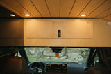 Cozy rv rental camper van interior: wood ceiling & cabinets, LED lights, and a scenic view through the windshield.