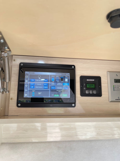Detailed view of an RV rental's internal control panel, displaying essential Airstream system info and gauges.