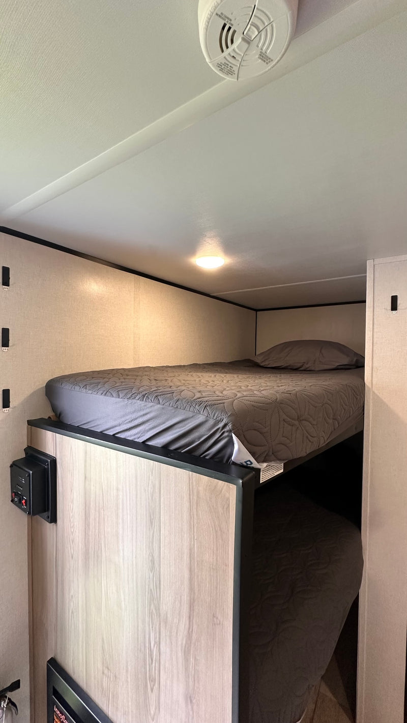  fire extinguisher by the open door to the outdoors.|Cozy rv rental interior with a bed — photo 10