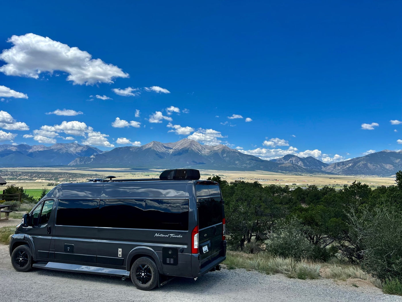  and cloudy skies.|Dark gray RV rental camper van parked on gravel — photo 8