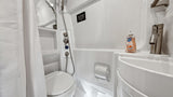 Inside a compact RV rental bathroom, showing the integrated shower, toilet, and sink.