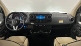 Experience comfort in this Mercedes-Benz RV rental! View of the dashboard, infotainment screen, steering wheel, and cream leather seats.