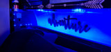 Escape in comfort! This RV rental bunk features blue LED lighting, an adventure sign, and a visible fire extinguisher.
