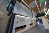 Modern campervan rv rental interior: custom storage, wood-slat ceiling with LED lights, and durable flooring for comfortable travel.