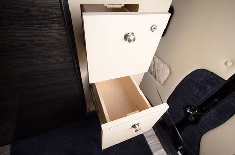 RV rental storage: Open drawers with light wood in a motorhome, featuring a locking top drawer and quilted interior.