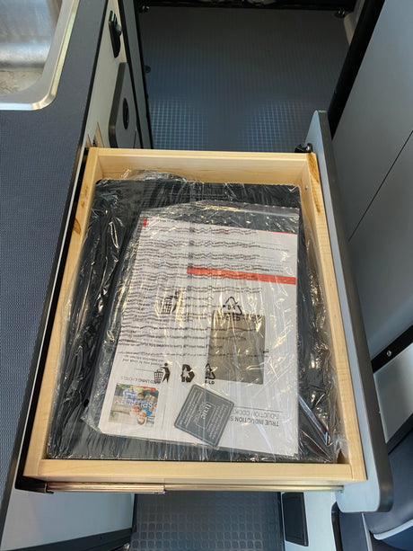 New True Induction cooktop and manuals in an RV rental drawer, ready for compact cooking adventures.