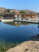Serene lake scene featuring wooden cabin rentals and an egret. Explore diverse lodging near RV rental options.