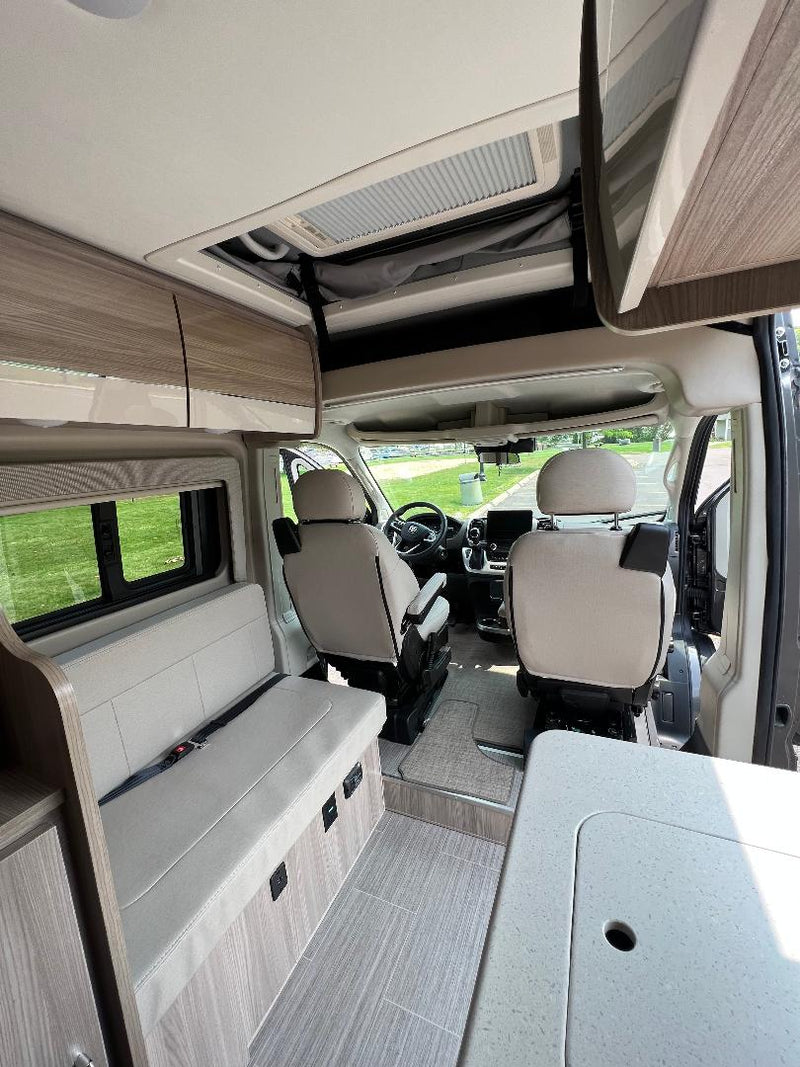  and front seats on wood-look flooring.|Experience an RV rental: clean interior with wood finishes — photo 16
