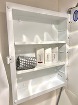 Compact white medicine cabinet in an RV rental, stocked with travel-sized Native brand toiletries & a towel. Jensen cabinet.