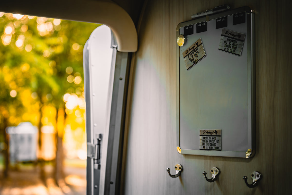 Humorous El Arroyo signs on a magnetic board inside an RV rental, offering a witty take on travel life. Sunny outside! — photo 4
