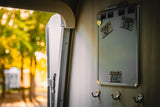 Humorous El Arroyo signs on a magnetic board inside an RV rental, offering a witty take on travel life. Sunny outside!