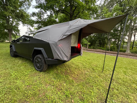  with a rear tent and awning in a grassy field.|Unique truck bed tent setup