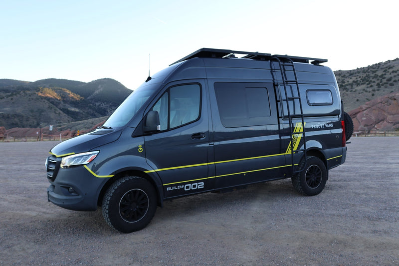  is parked against a mountain backdrop.|Dark gray custom 'Remote Vans' camper van with yellow stripes — photo 11