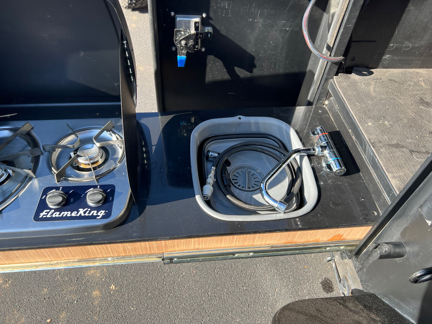 RV rental outdoor kitchen: a FlameKing stove and portable sink with pull-out faucet for convenient cooking.