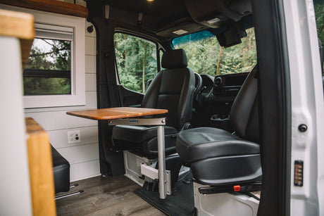 RV rental interior: Swivel front seats, adjustable table, and window offer comfort in this camper van.