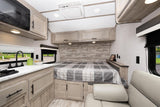 Cozy RV rental interior shows kitchenette, built-in bed, and sofa. Light wood finishes & clever storage maximize compact space.