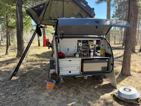 This overland trailer with a deployed rooftop tent and fully-equipped outdoor kitchen makes for an ideal rv rental for camping adventures.