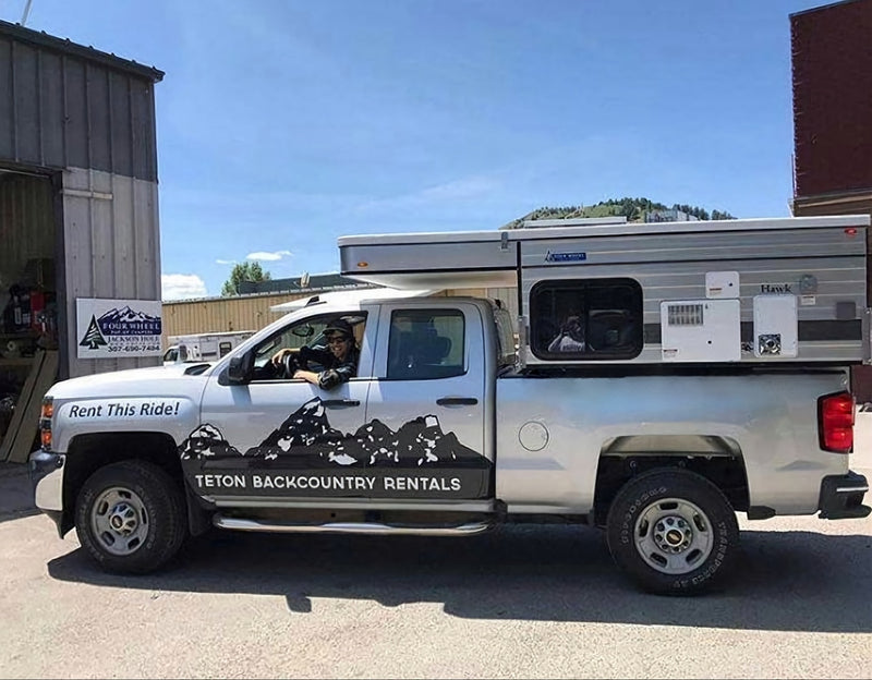 This silver pickup truck with a pop-up truck camper is an ideal RV rental for outdoor adventure! — photo 6
