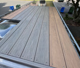 RV rental featuring a unique two-tone rooftop deck (gray & brown boards) and solar panels, ideal for outdoor living.