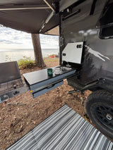 RV rental: outdoor kitchen (sink, stove) extended from a travel trailer, by a lake. Camping with a view!
