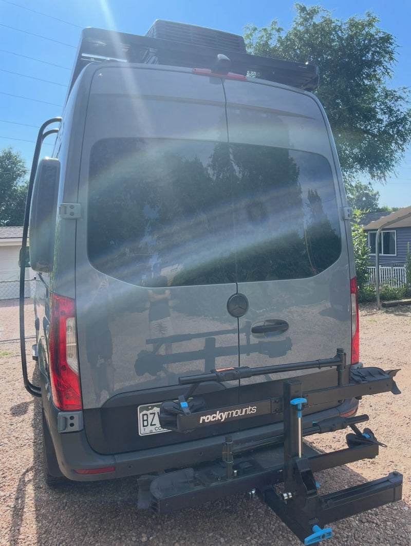  is heavily snowed in with deep drifts & snowy mountains behind it.|Gray rv rental van — photo 2
