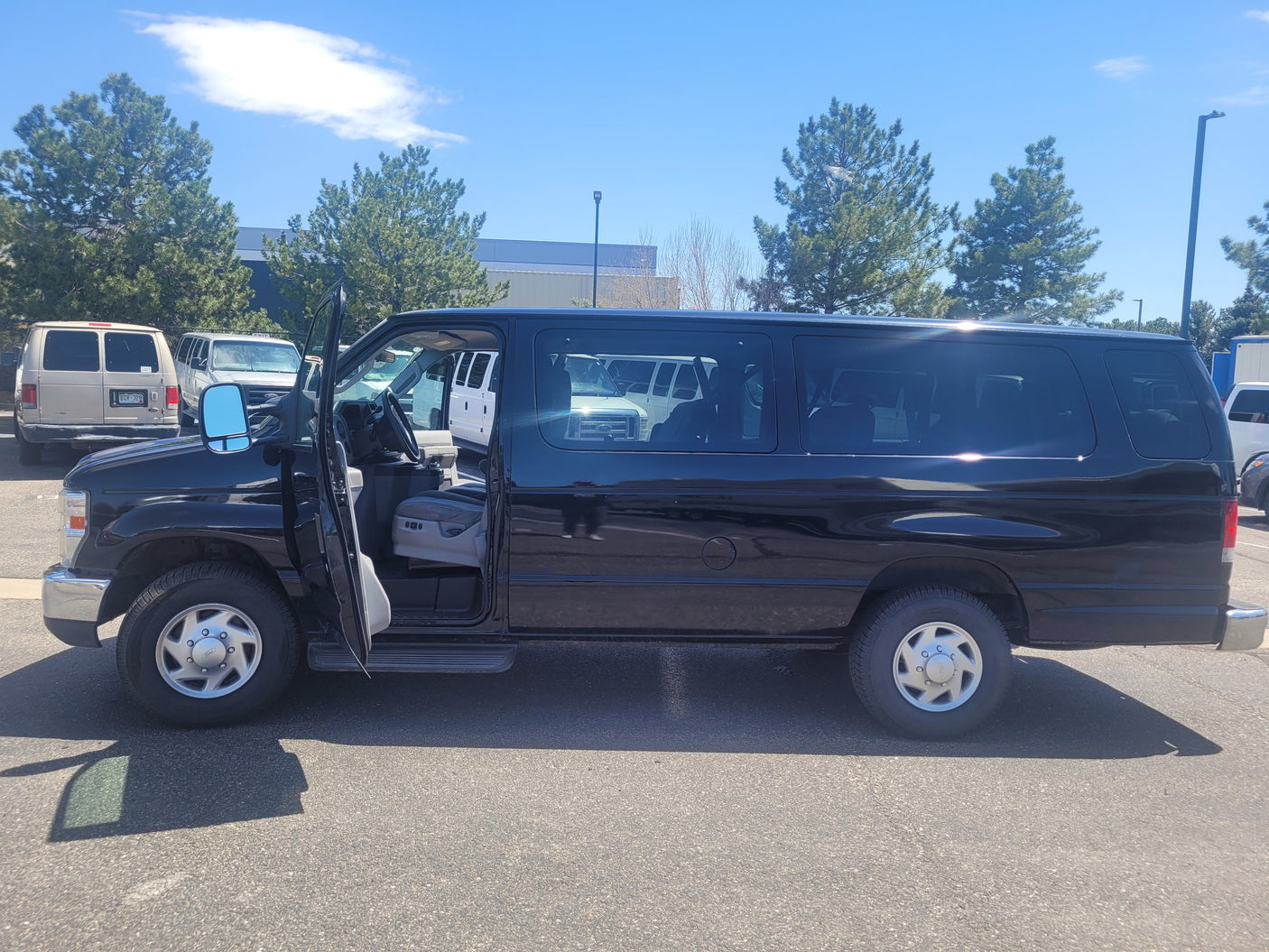 Black passenger van, driver's door open. Ideal for groups, available through an rv rental service.