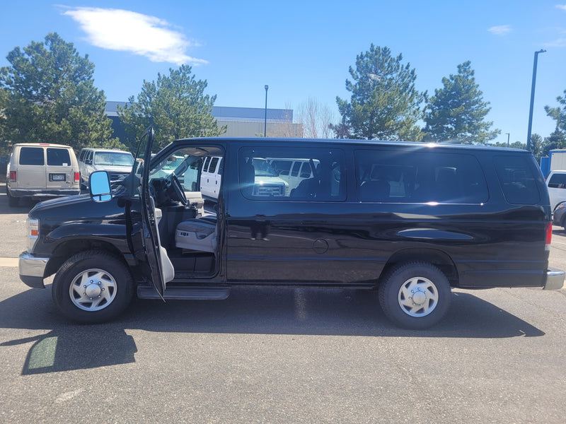  parked beside a large RV in a sunny lot. Perfect for your next RV rental adventure.|Inside an rv rental van: driver's perspective with steering wheel — photo 11