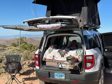 SUV with rooftop tent & kitchen, ready for camping. Ideal RV rental for outdoor adventures!