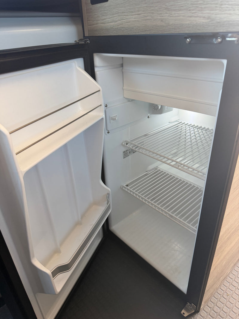  and a scenic window view.|rv rental: Interior of a camper van featuring a compact kitchenette — photo 10