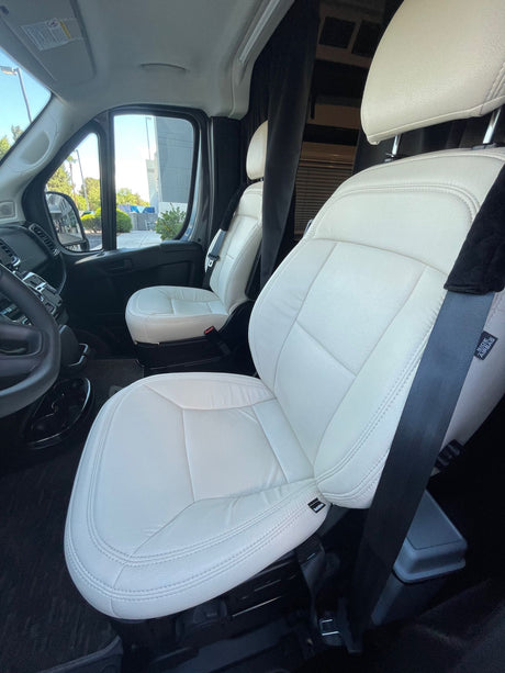 Inside an RV rental: Bright white, clean front seats with clear views outside. Prepped for a comfortable journey.
