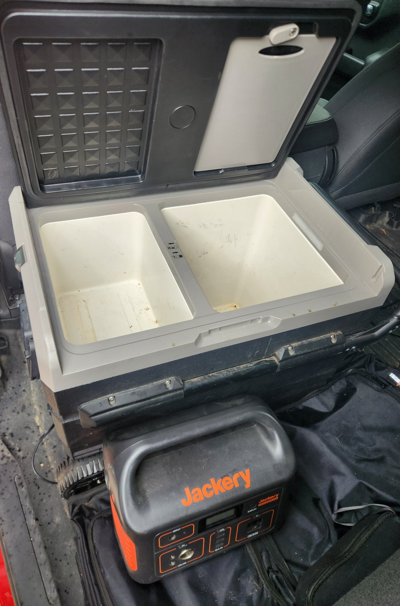 Inside an RV rental: a portable fridge-freezer with two compartments and a Jackery power station, ideal for off-grid adventures.