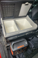 Inside an RV rental: a portable fridge-freezer with two compartments and a Jackery power station, ideal for off-grid adventures.