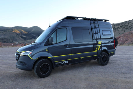 This customized Mercedes-Benz Sprinter camper van, perfect for rv rental adventures, is parked against a mountain backdrop.
