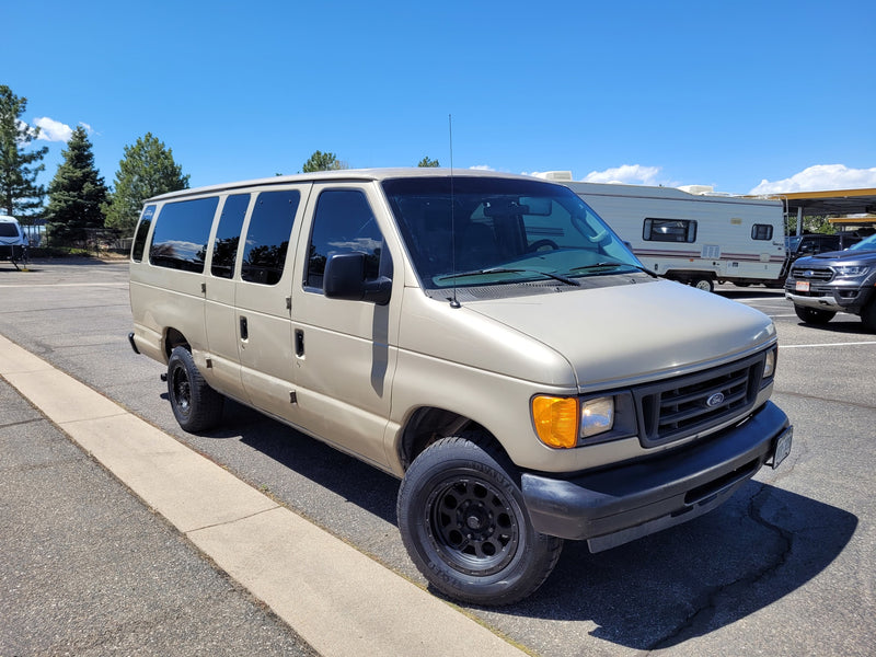 Tan Ford van and a white RV in a sunny lot. Explore rv rental possibilities in this vibrant setting! — photo 10