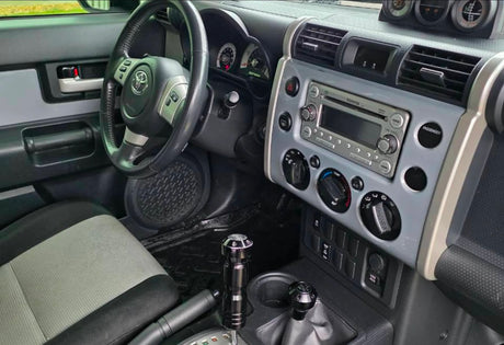 Toyota FJ Cruiser car interior: steering wheel, dashboard, and controls. Ideal for an adventurous RV rental journey.