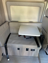 Modern RV rental dinette with comfortable seating, adjustable table, safety seatbelts, power outlets, and tiled floor.