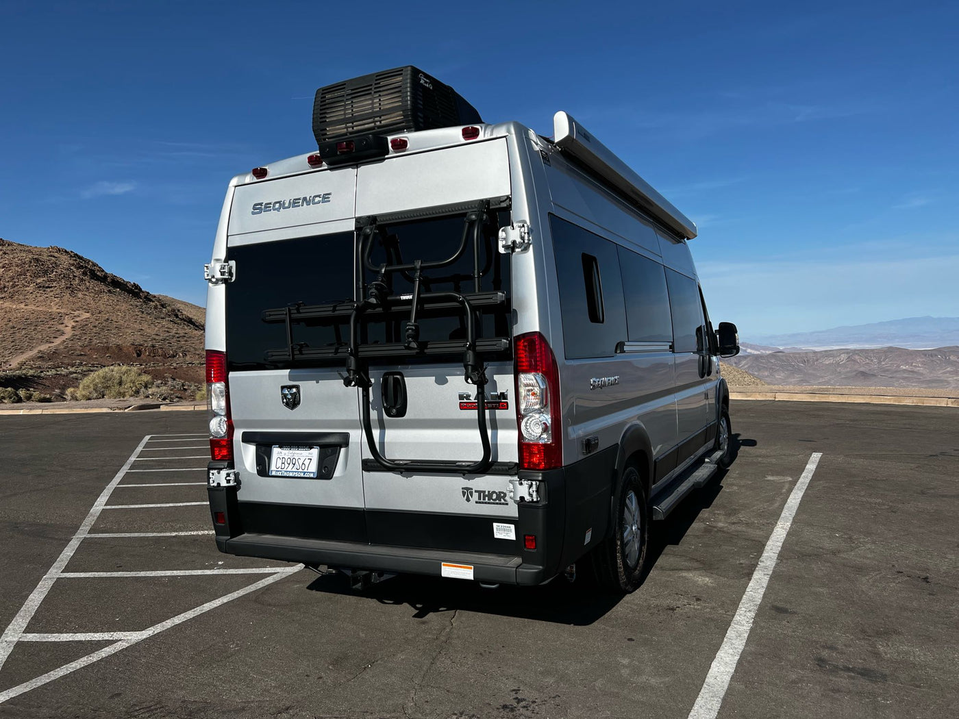 Silver Thor Sequence rv rental, with bike rack, parked at a desert mountain viewpoint under clear blue skies. — photo 19