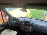 Inside an RV rental van: Driver's view showing the dashboard, steering wheel, and the road ahead through the windshield.
