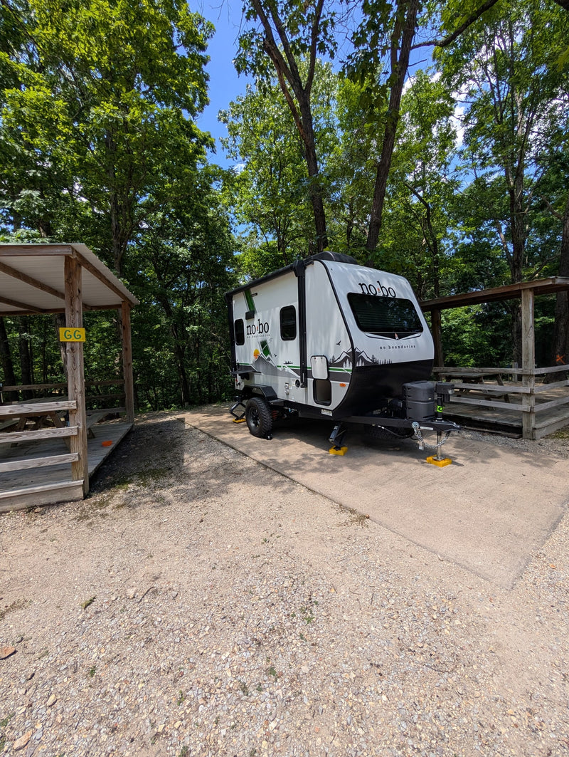 White No Boundaries RV rental at a shaded campsite with a picnic shelter, ready for outdoor adventure. — photo 6
